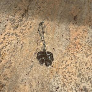 Woman's bracelet with a silver plated leaf charm at the end of the bracelet